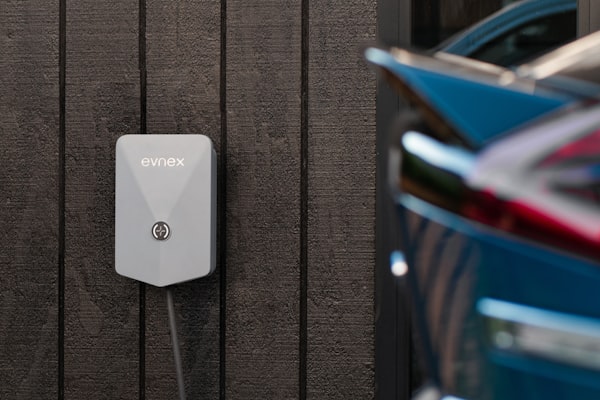 EV charger mounted on wall with car plugged in